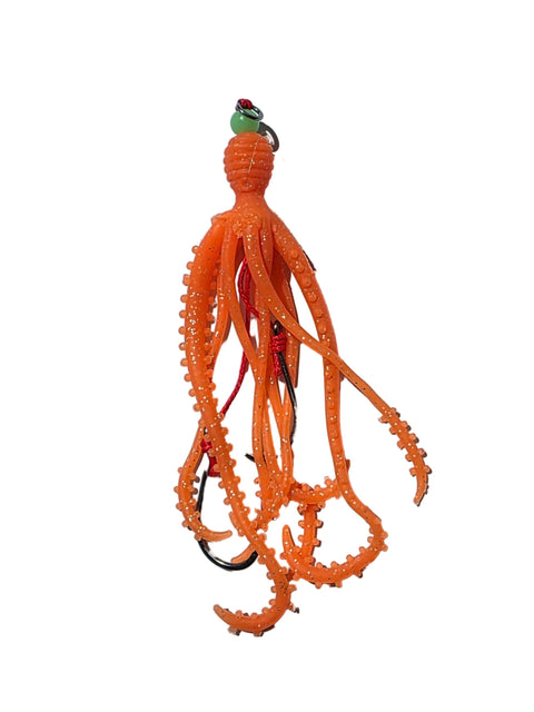 Orange fishing lure on a white sheet of paper